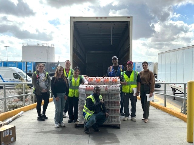 Amazon team members at BC employees accepting a pallet of food and drinks in front of a semi truck