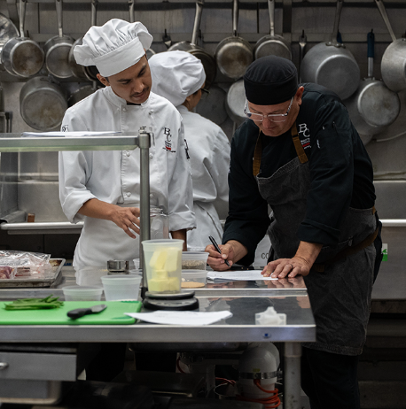Chef teaching culinary student