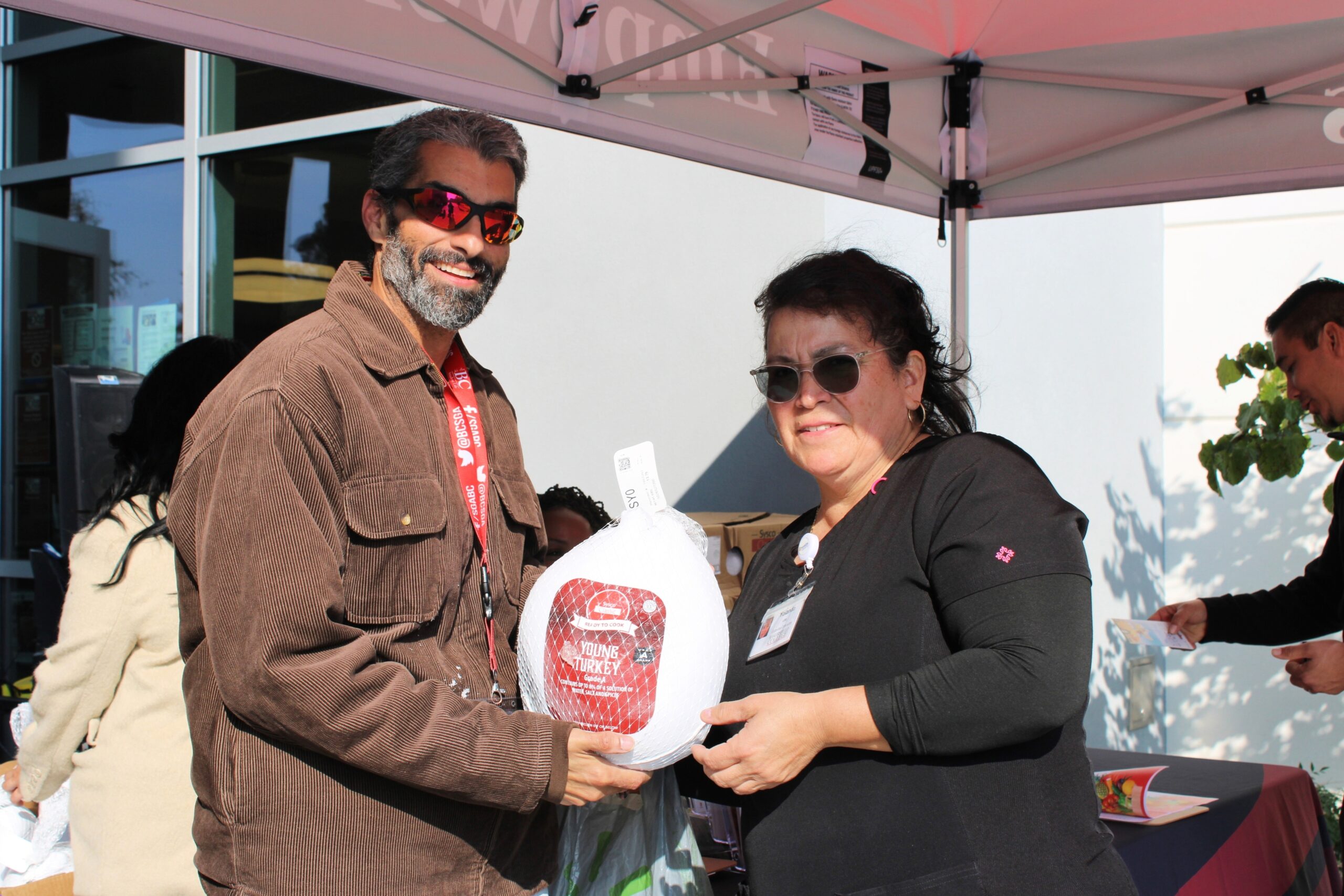Dean of students giving a turkey to a staff member