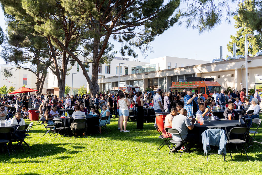 People gathered outside on and around tables