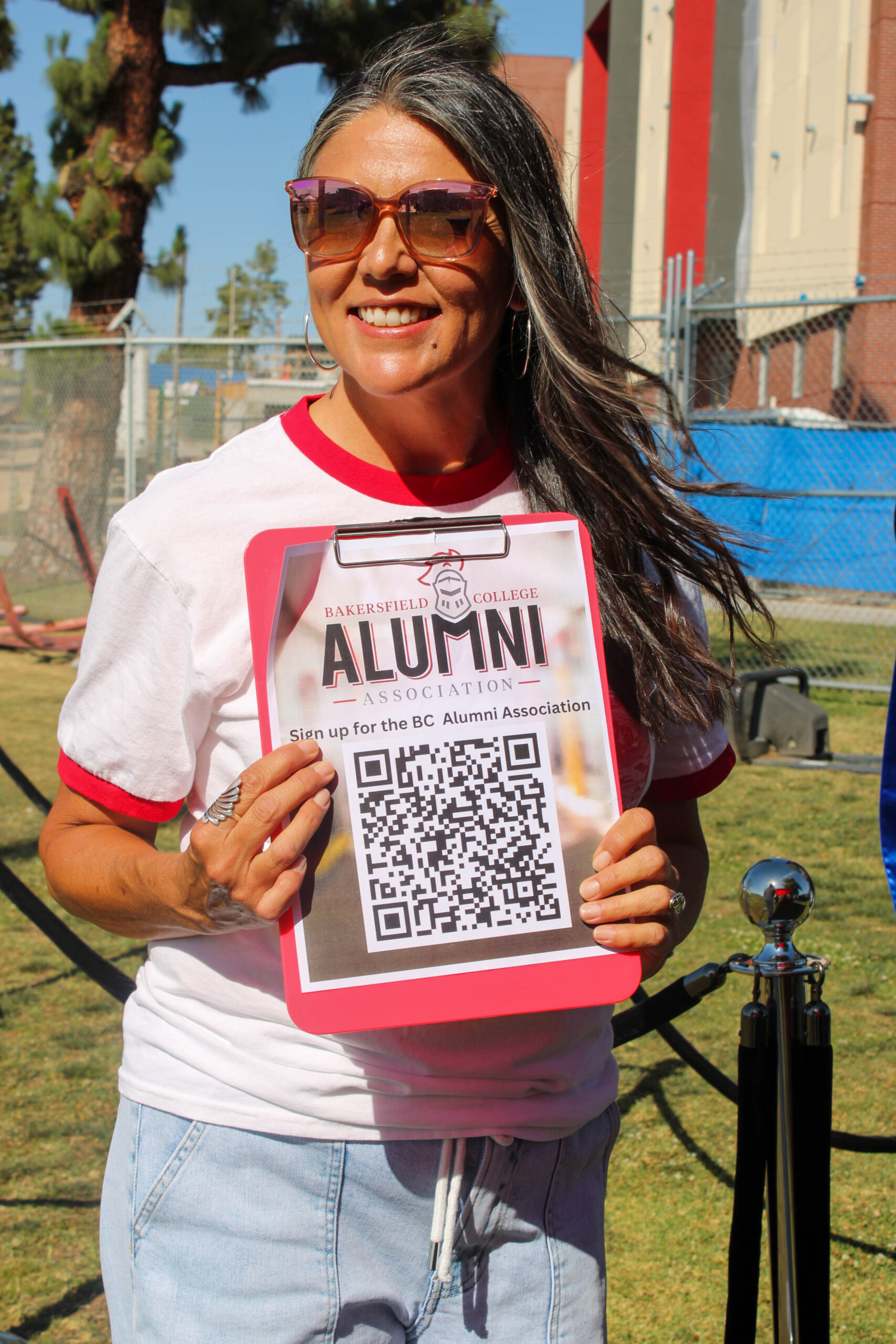 Alumni Association board member holding up a sign up QR code.