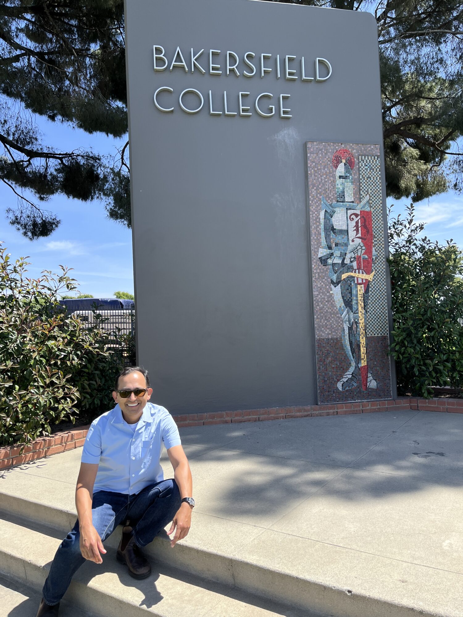 Israel Moya sitting in front of a Bakersfield College sign