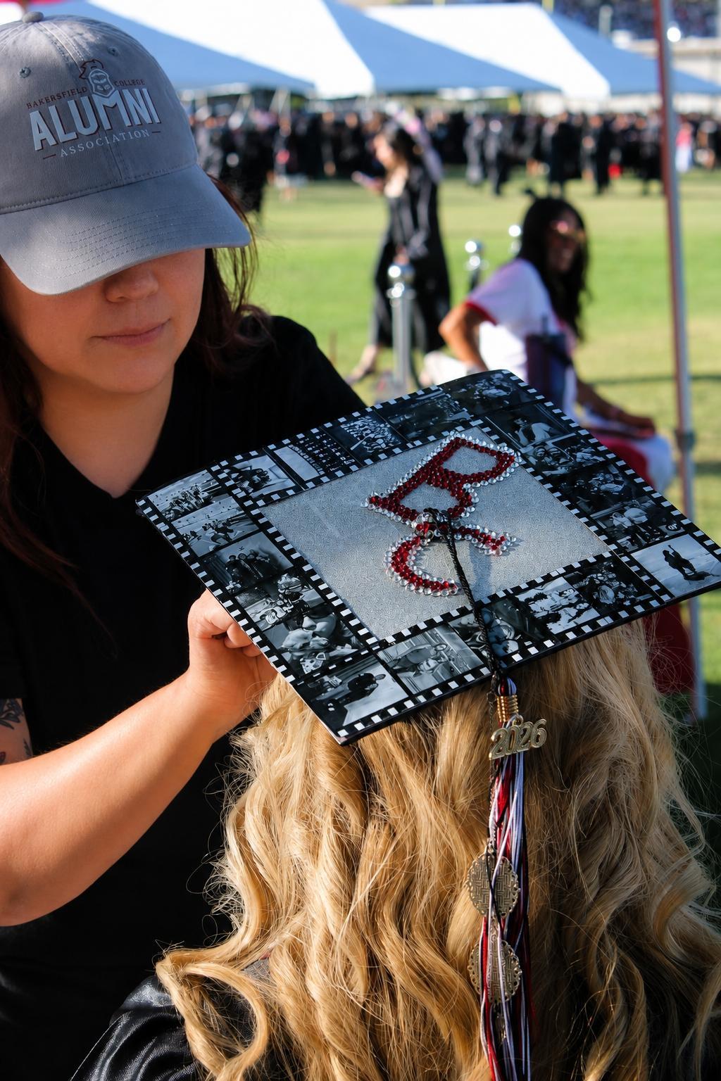 A volunteer pinning a graduates cap