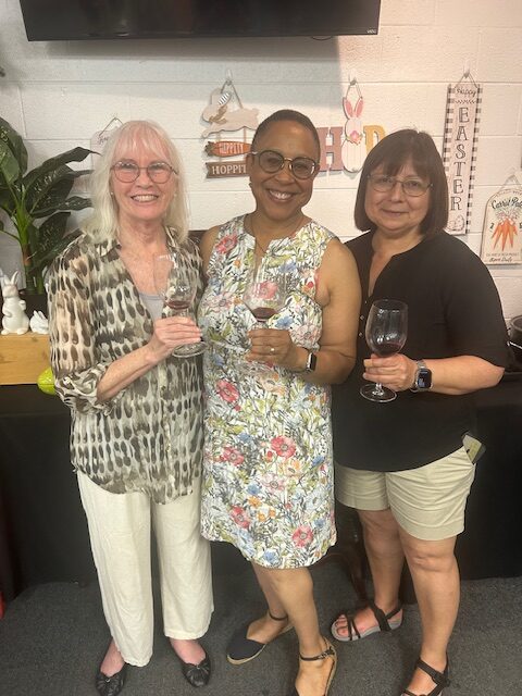 Three ladies holding wine glasses