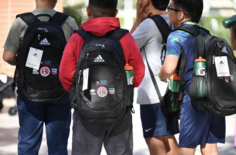 Four kids wearing backpacks