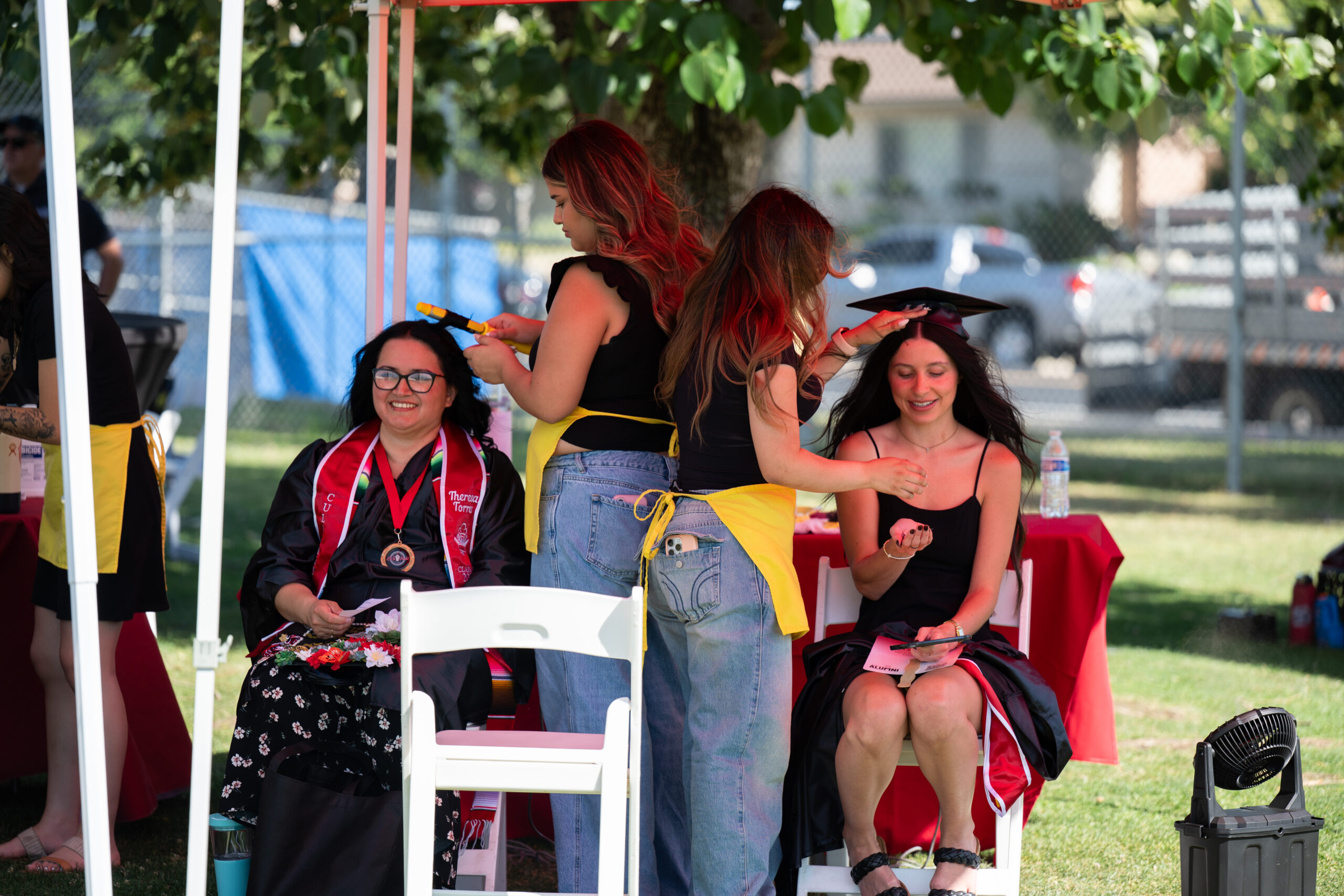Two graduates getting their hair styled