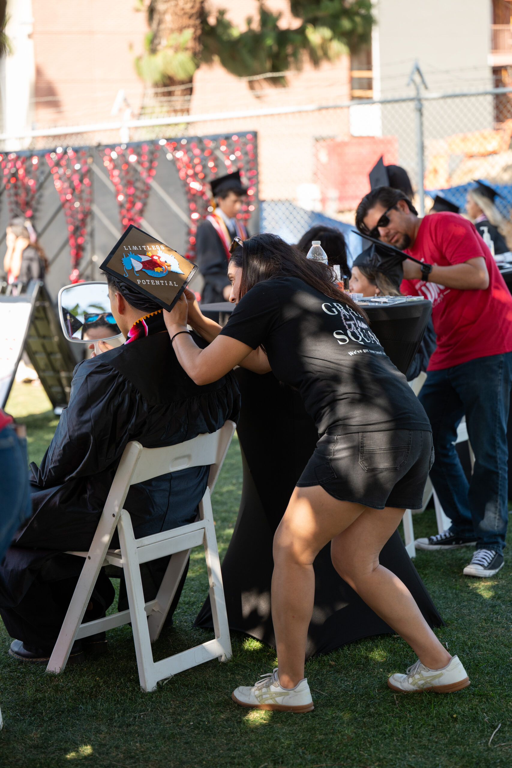 Volunteers pinning a graduates cap