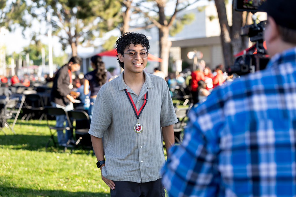 Scholarship recipient smiling in front of a camera