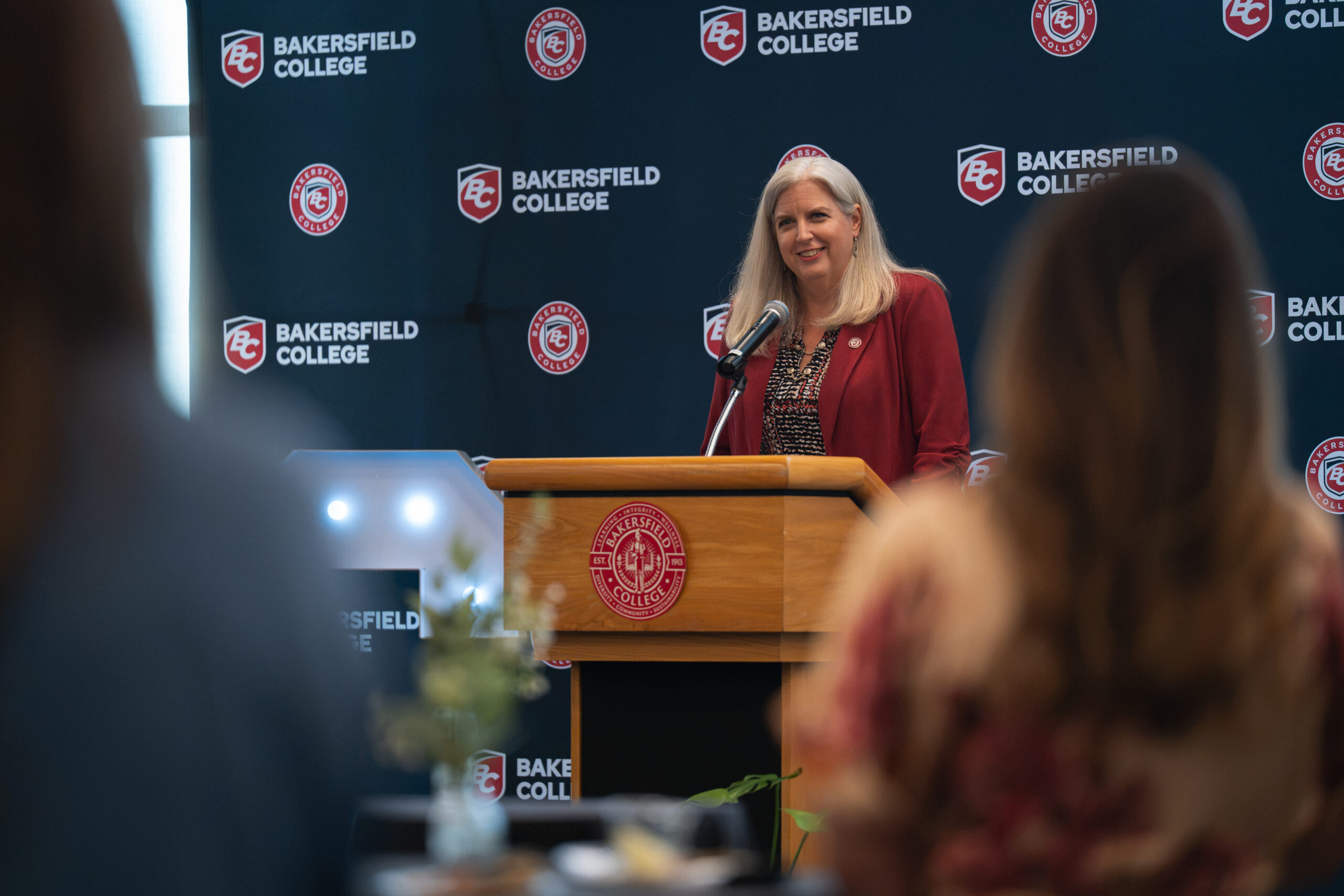 President Stacy Pfluger speaks to guests from a podium
